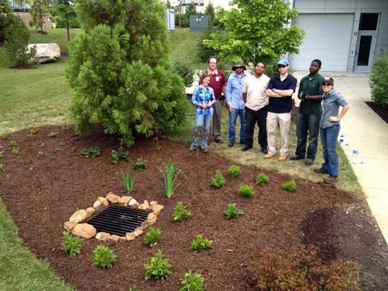 READY program participants pose next to a finished rain garden