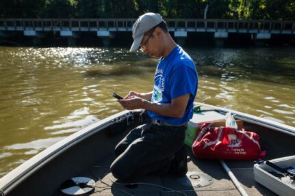Masaya Maeda, a water quality specialist, records water monitoring data on the Anacostia River.