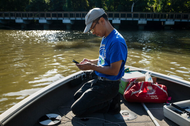 Masaya Maeda, a water quality specialist, records water monitoring data on the Anacostia River.