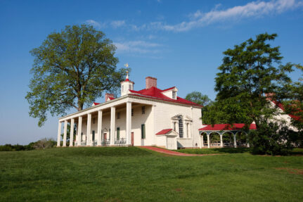 Mount Vernon is a white building with tall columns and a red roof.