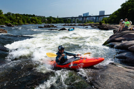 Kayakers paddle through rapids on the James River in Richmond, Virginia.