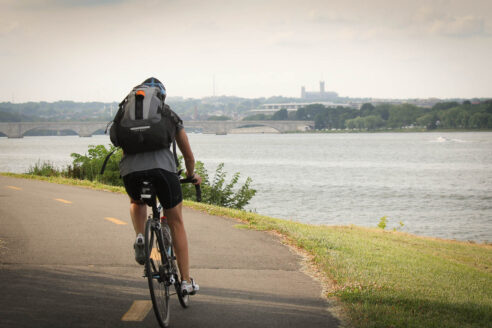 A biker rides along the Mount Vernon Trail as it faces the river.