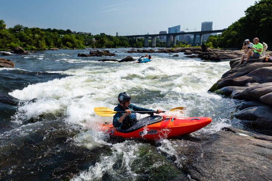 Kayakers paddle through rapids on the James River in Richmond, Virginia.