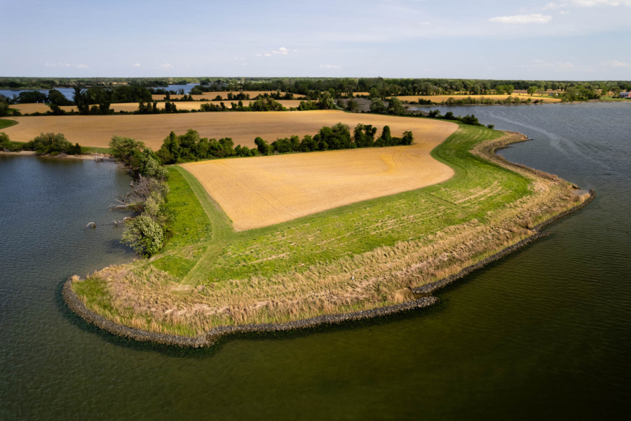 Aerial view of a low-vegetated shoreline and a farm.