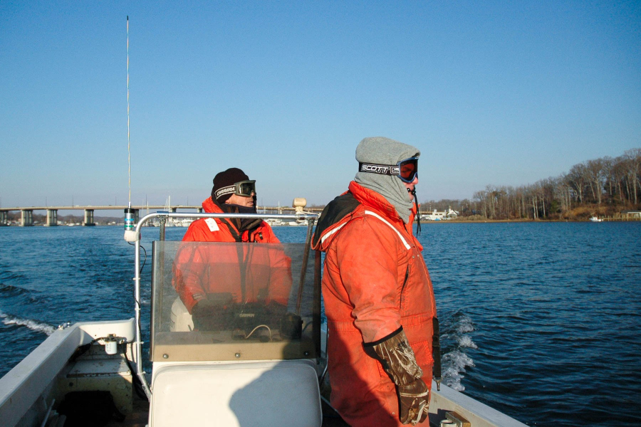 U.S. Fish and Wildlife staff don orange suits and face protection amid the intense cold.