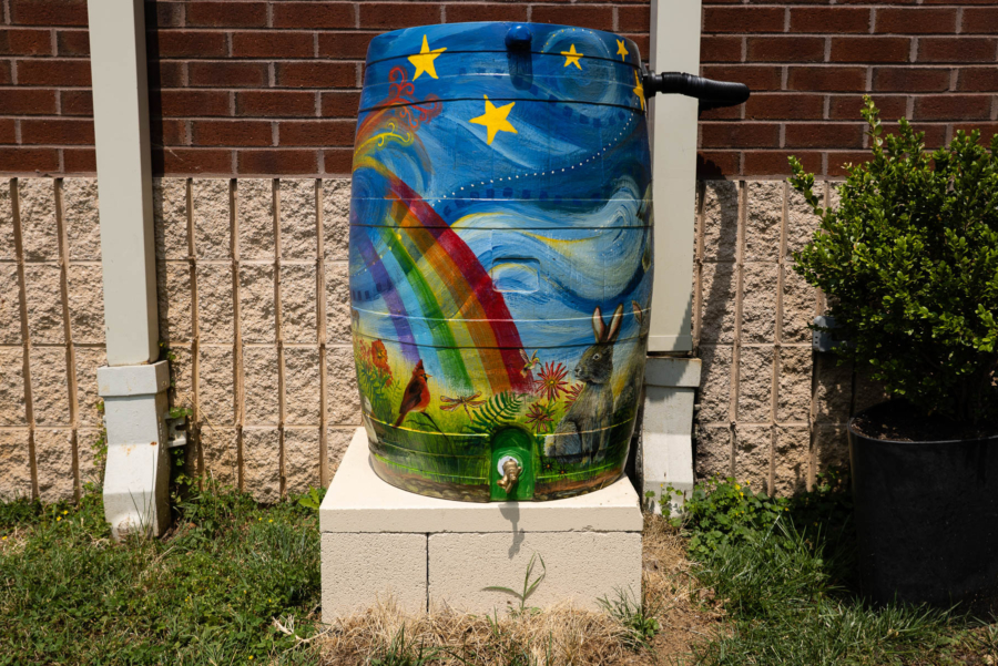 A painted rain barrel collects stormwater from the roof of a church.
