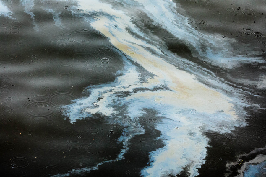 A murky puddle on the water from a fuel spill.