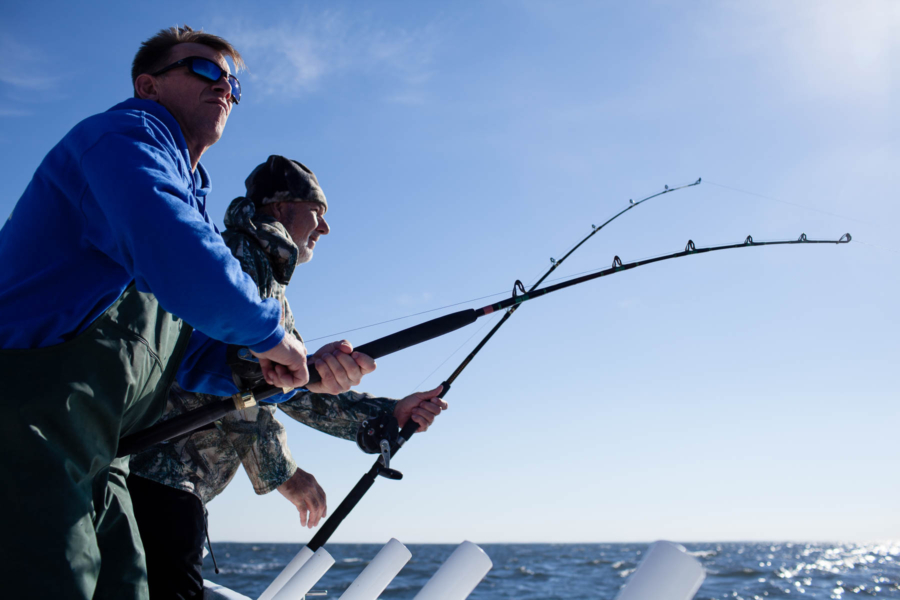 Two anglers cast from a boat.