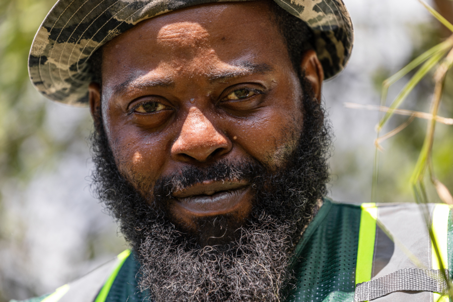 Sweat beads on the face of Young, shaded by a camouflage-colored floppy hat