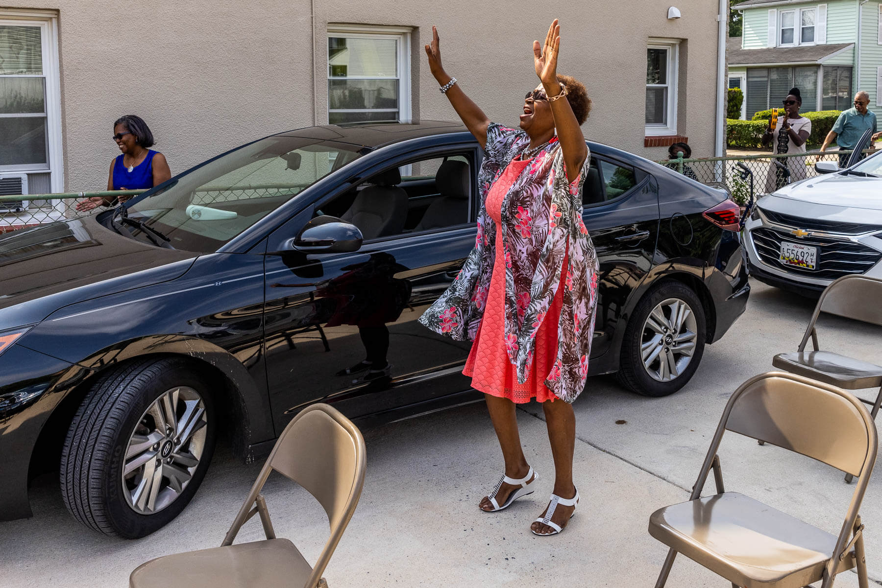 Heading to church, LuAnn Dillard raises her hands in praise.