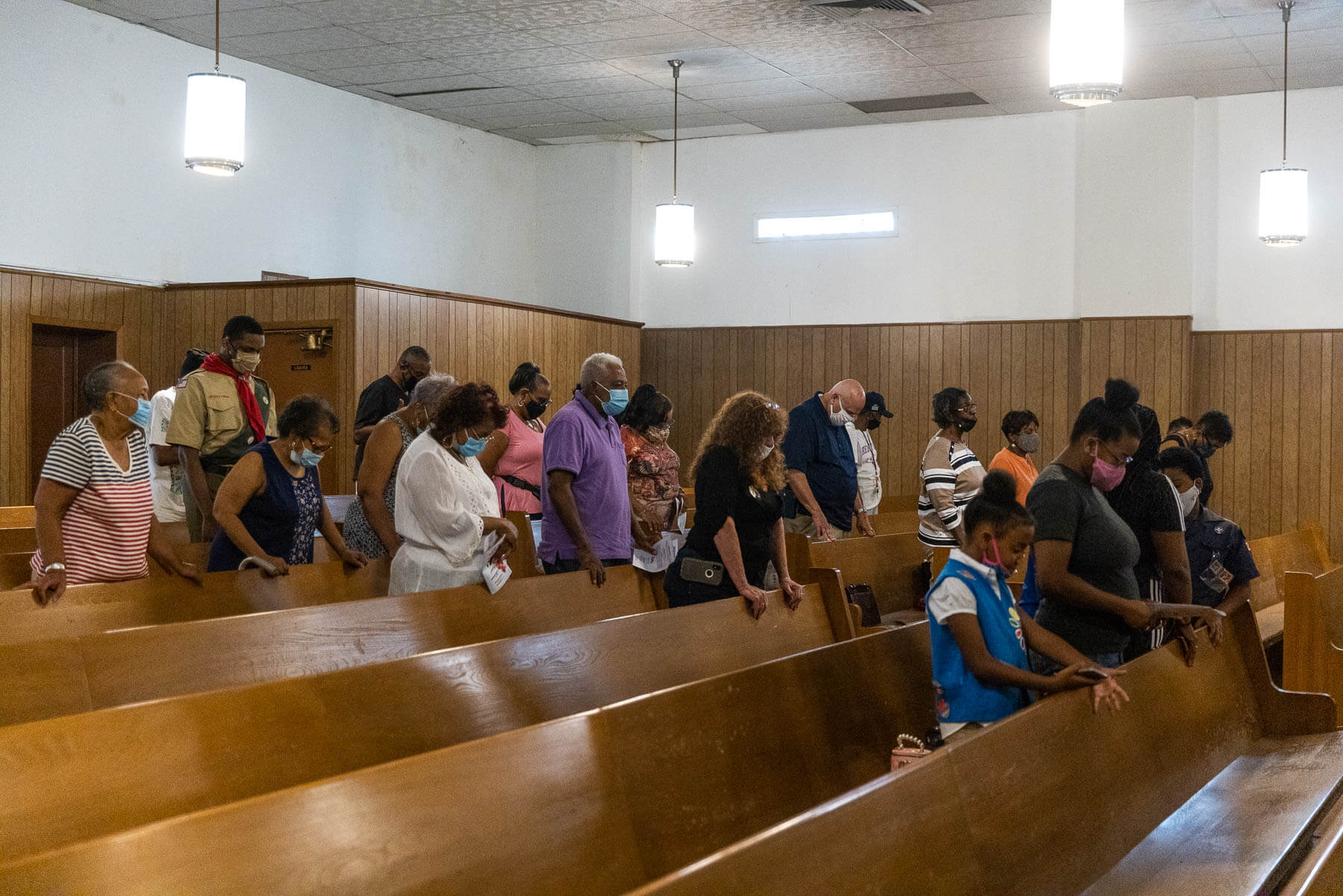 Residents of Turner Station bow their heads at church.