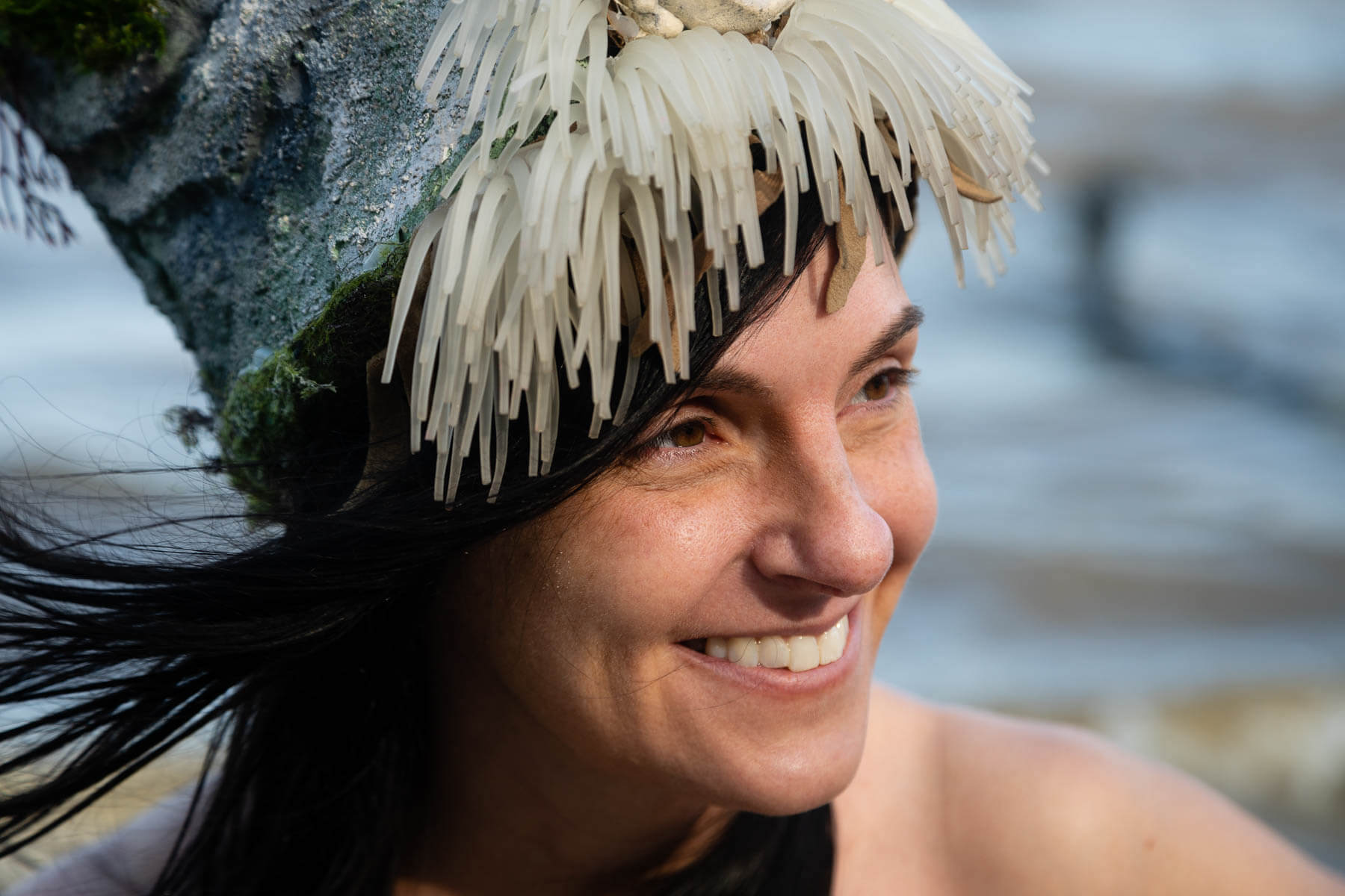 Close-up of woman's face with fringed hat on top
