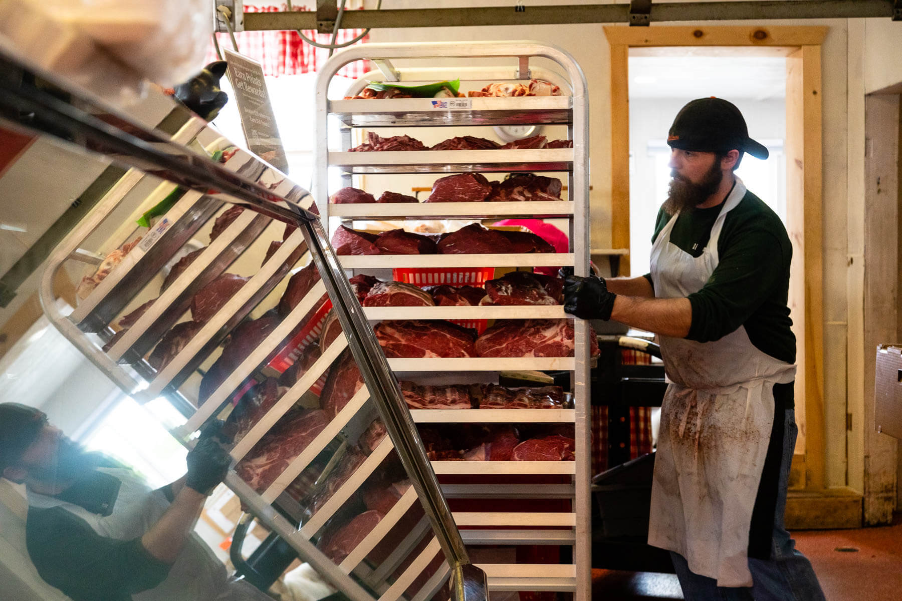 Butcher at Sudlersville Meat Locker hauls crates full of meat.