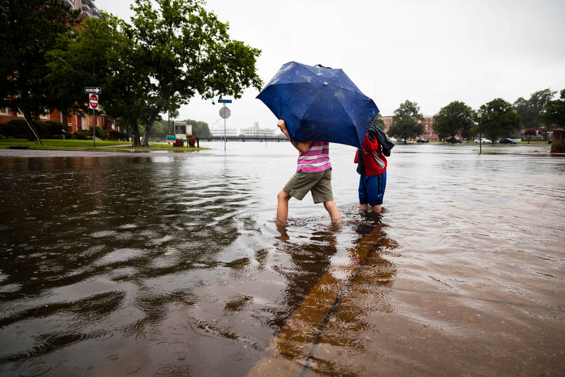 Kids plays in flooded street.