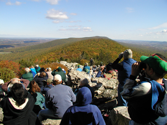 Bird watchers look for migrating birds of prey atop of Hawk Mountain